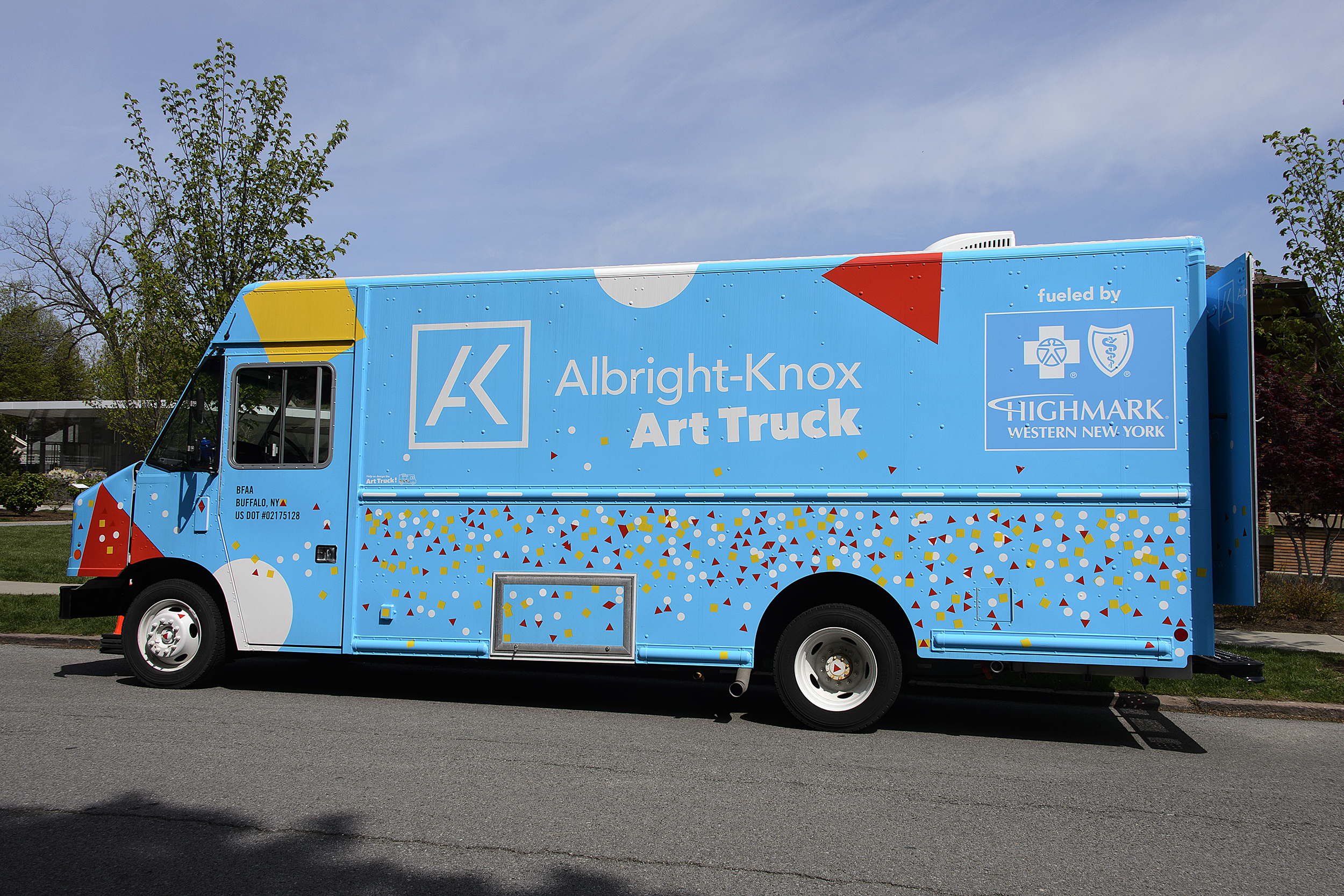 A large blue truck with red, yellow, and white shapes decorating it