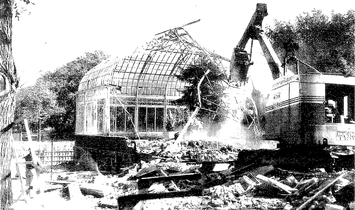 Black and white photo showing the demolition of a glass structure