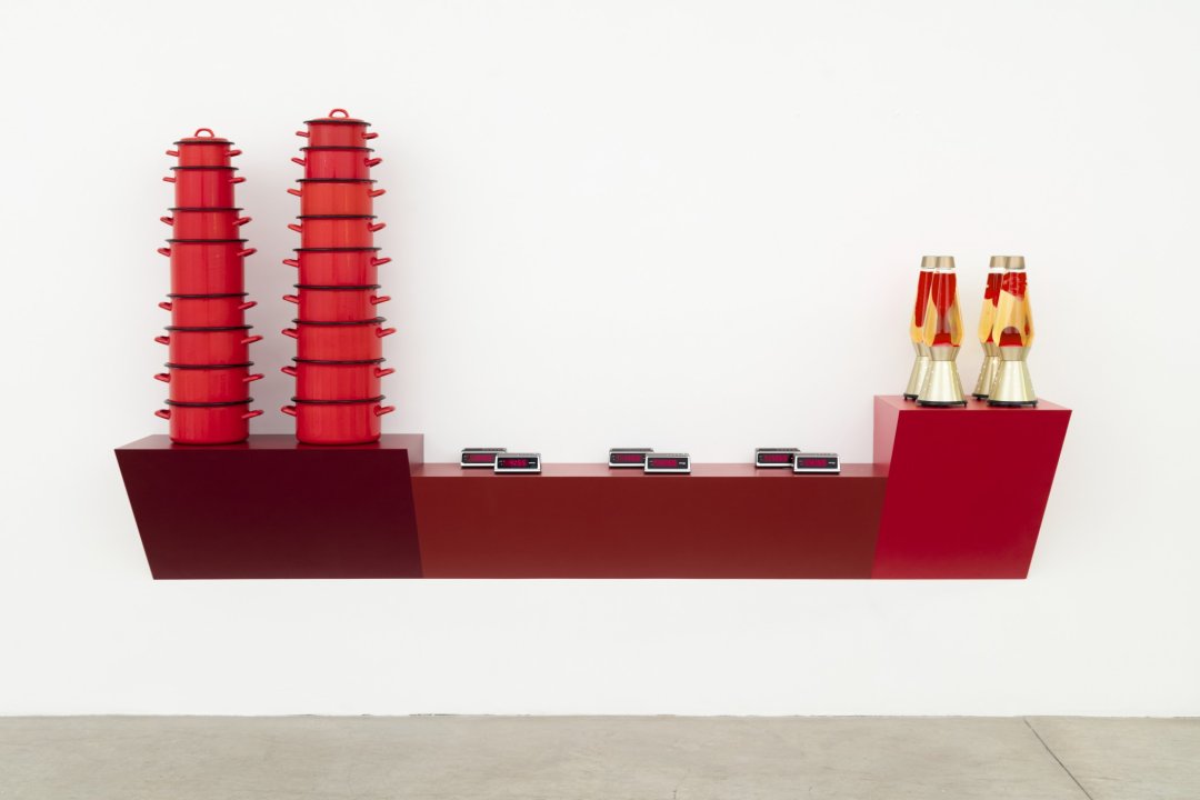 Sculpture made of plastic laminated wood shelf, seventeen red enameled cast iron pots, six plastic and metal digital clocks and four glass, metal and red colored oil - "Lava Lites"