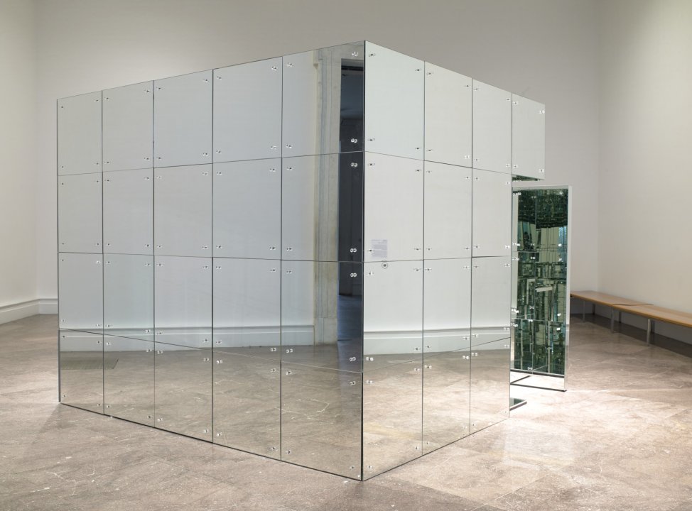 Large box/room covered in mirrors with a door ajar showing that the inside is also covered in mirrors 