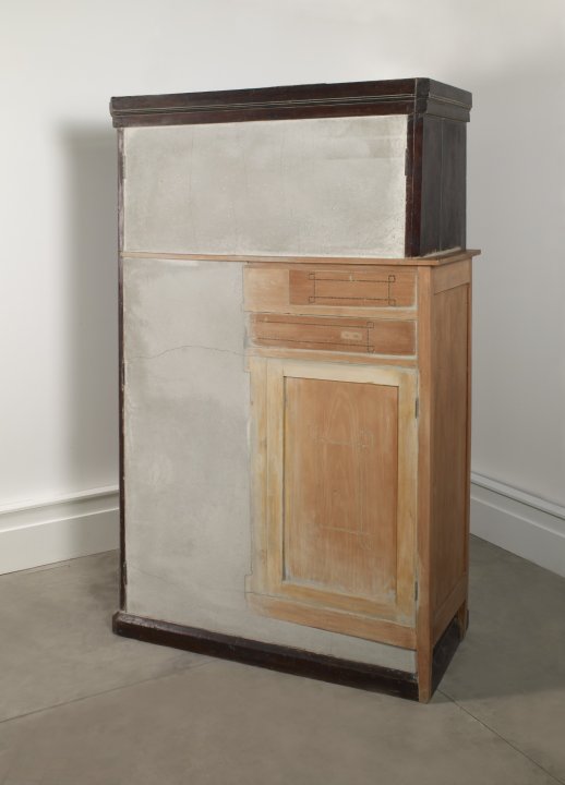 A brown wooden cabinet that is partially stained and has unfinished work on the front top and bottom left cabinet