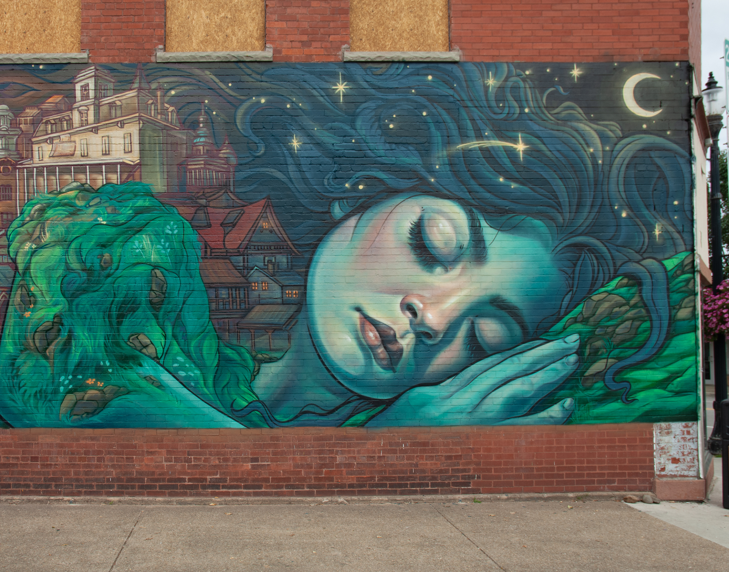 A mural of a green giant sleeping with head on hands