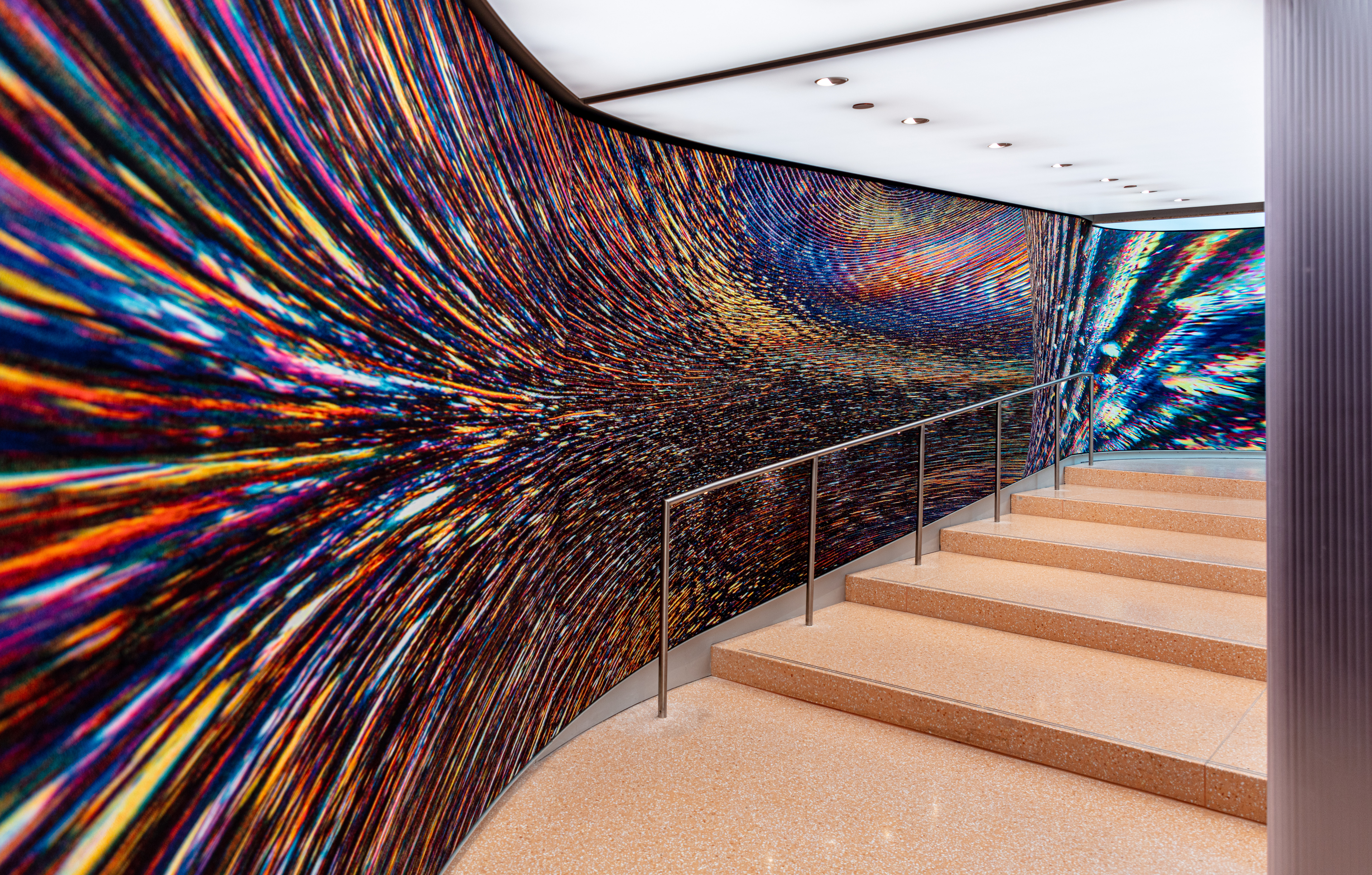 A dark colorful wall mural along a staircase