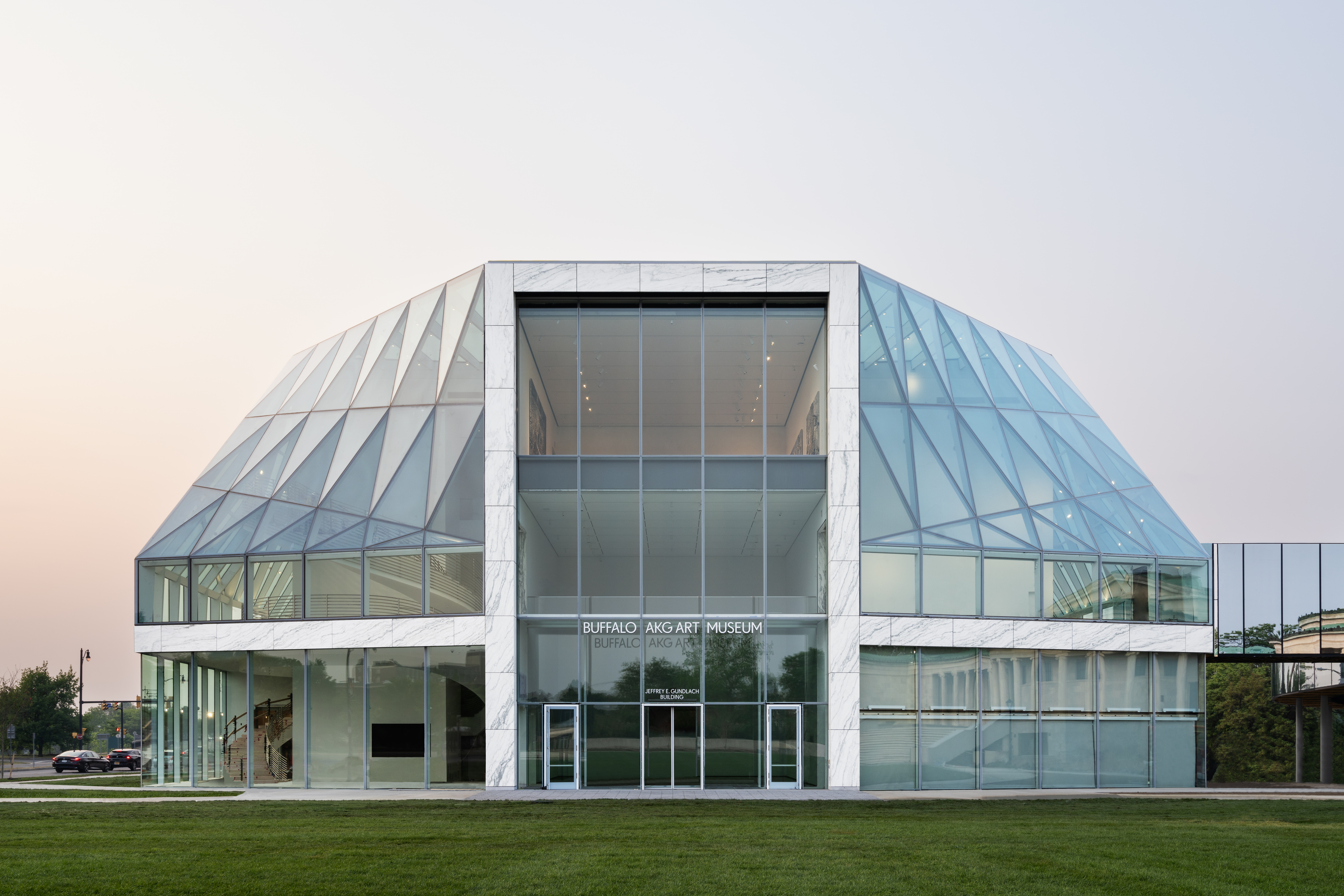 A large glass museum building at sunset