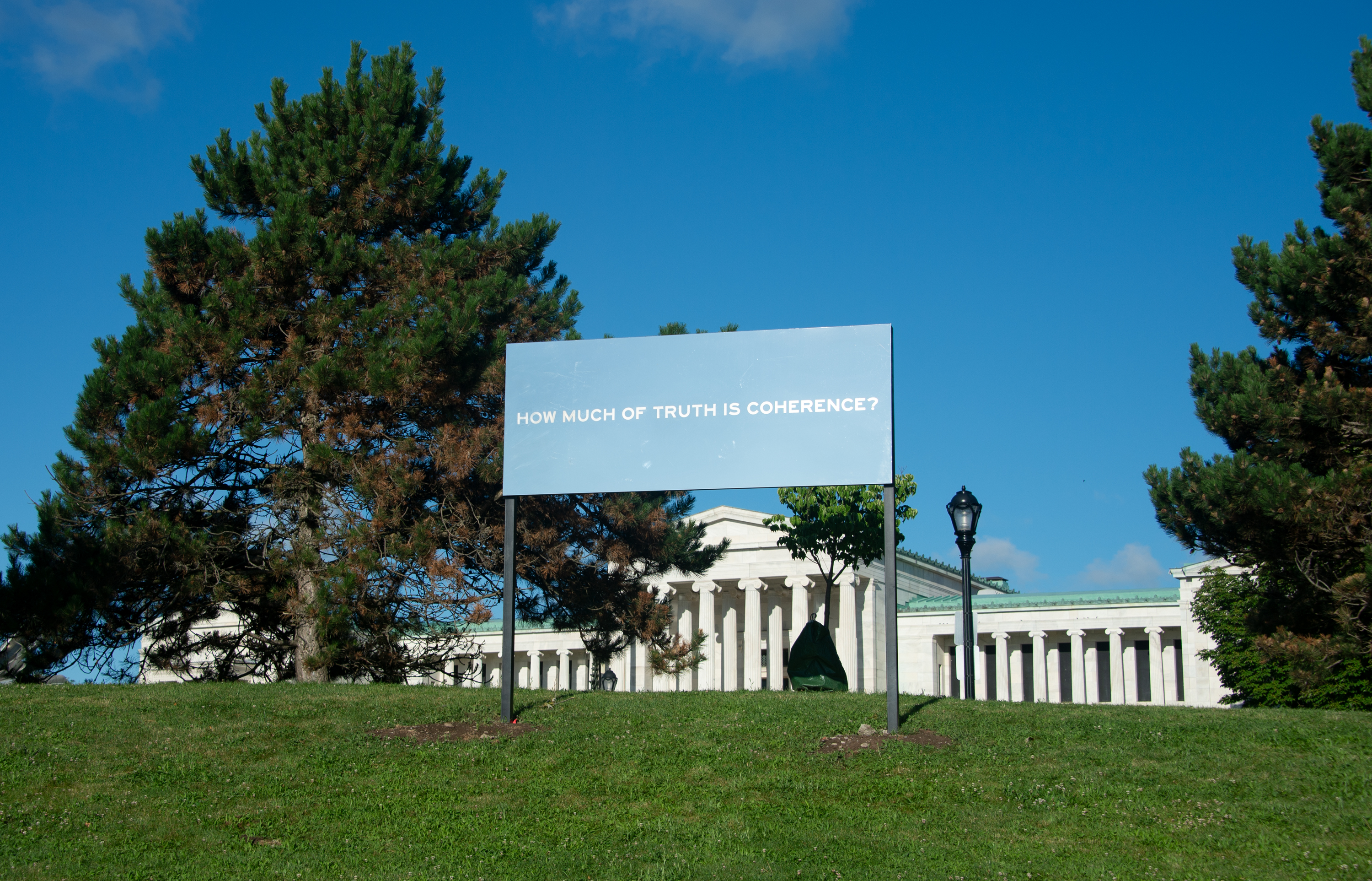 A mirrored billboard that reads "How much of truth is coherence?" 