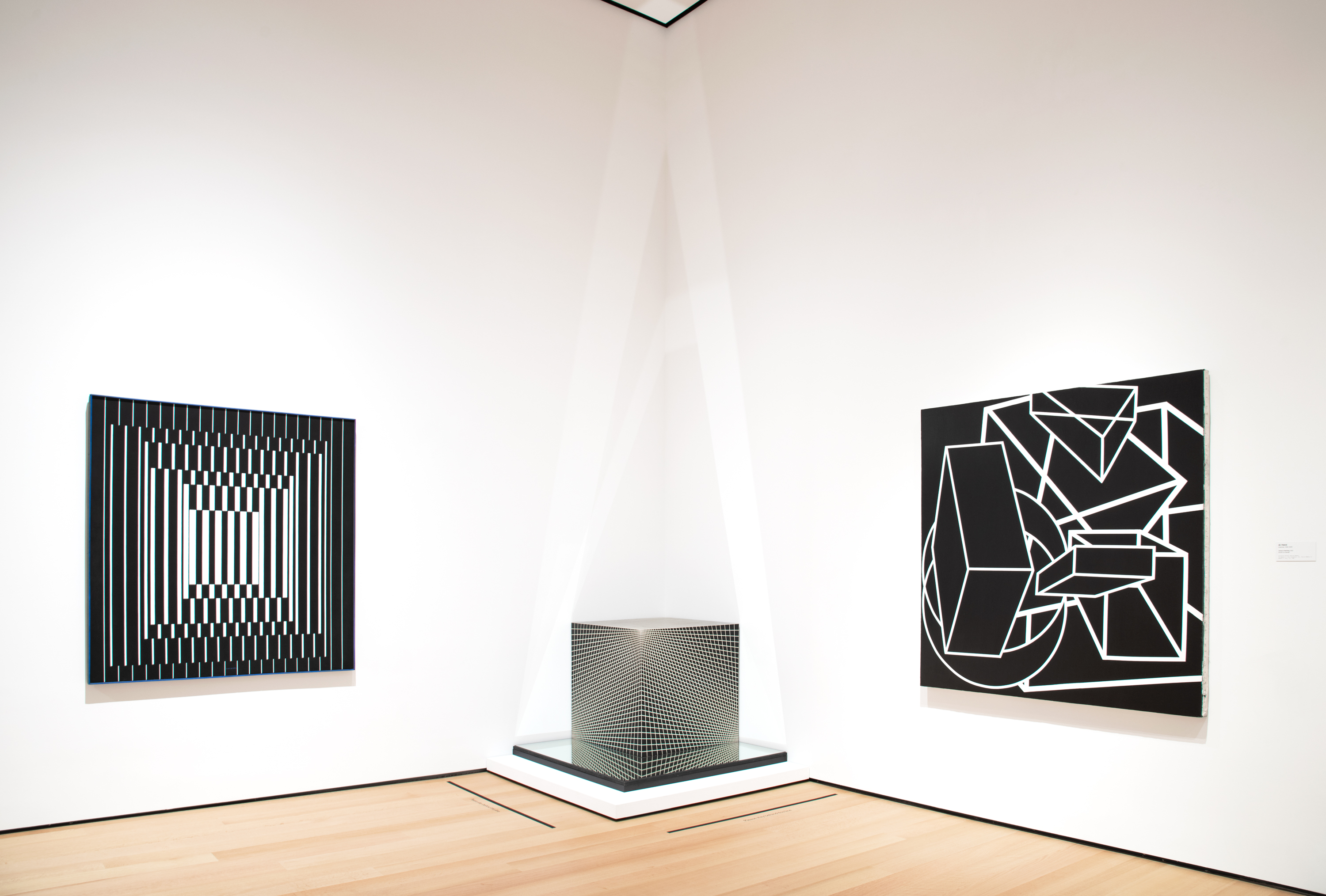 Installation view of three black and white works of Op art