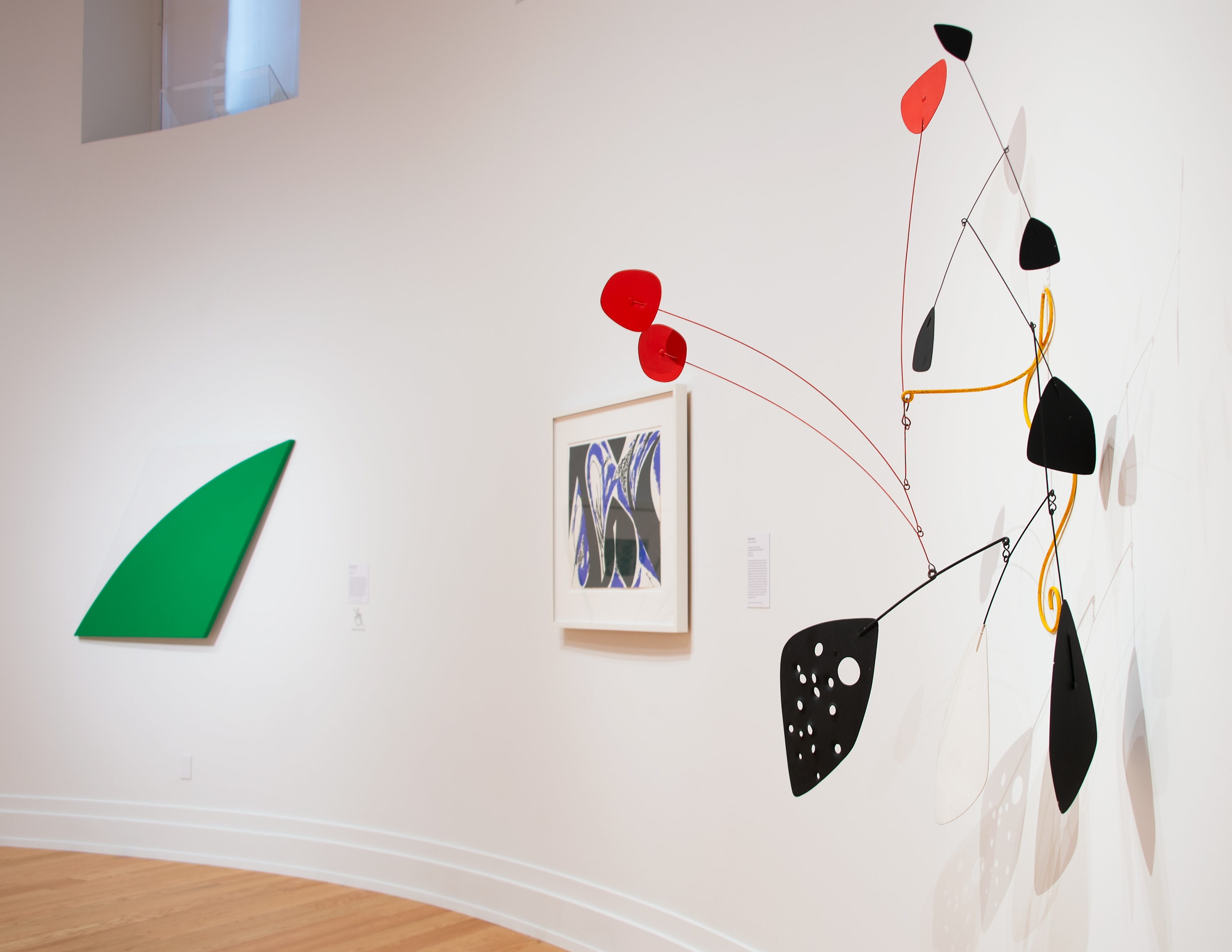 Installation view of a two paintings and a Calder work on a white wall