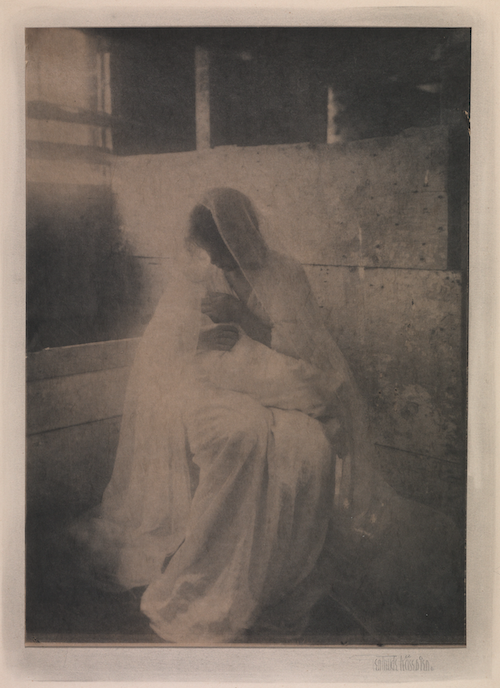 Old photograph of a woman in a veil holding a baby