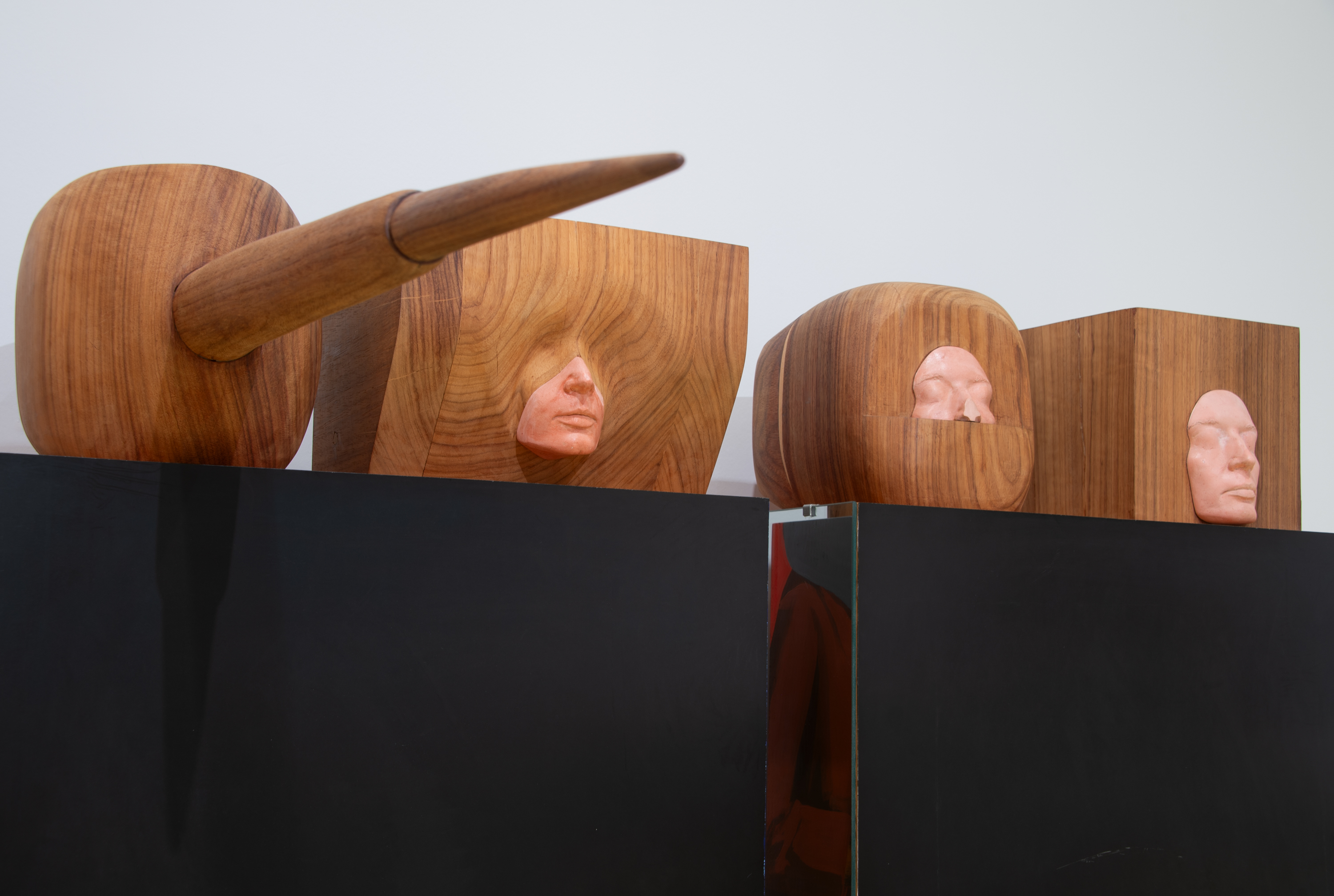 Closeup of faces of wooden sculptures by Marisol