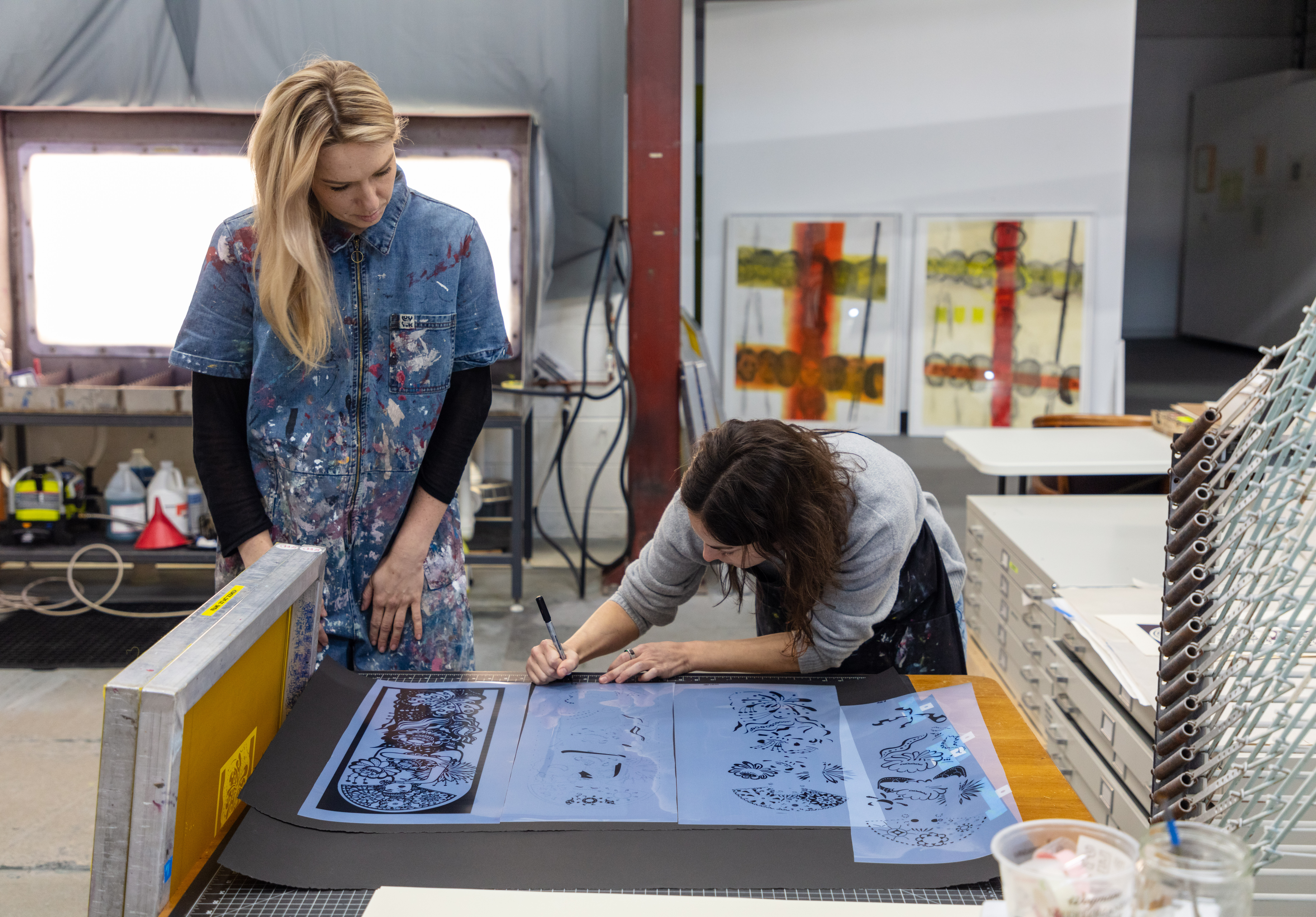 Two artists working in a print studio