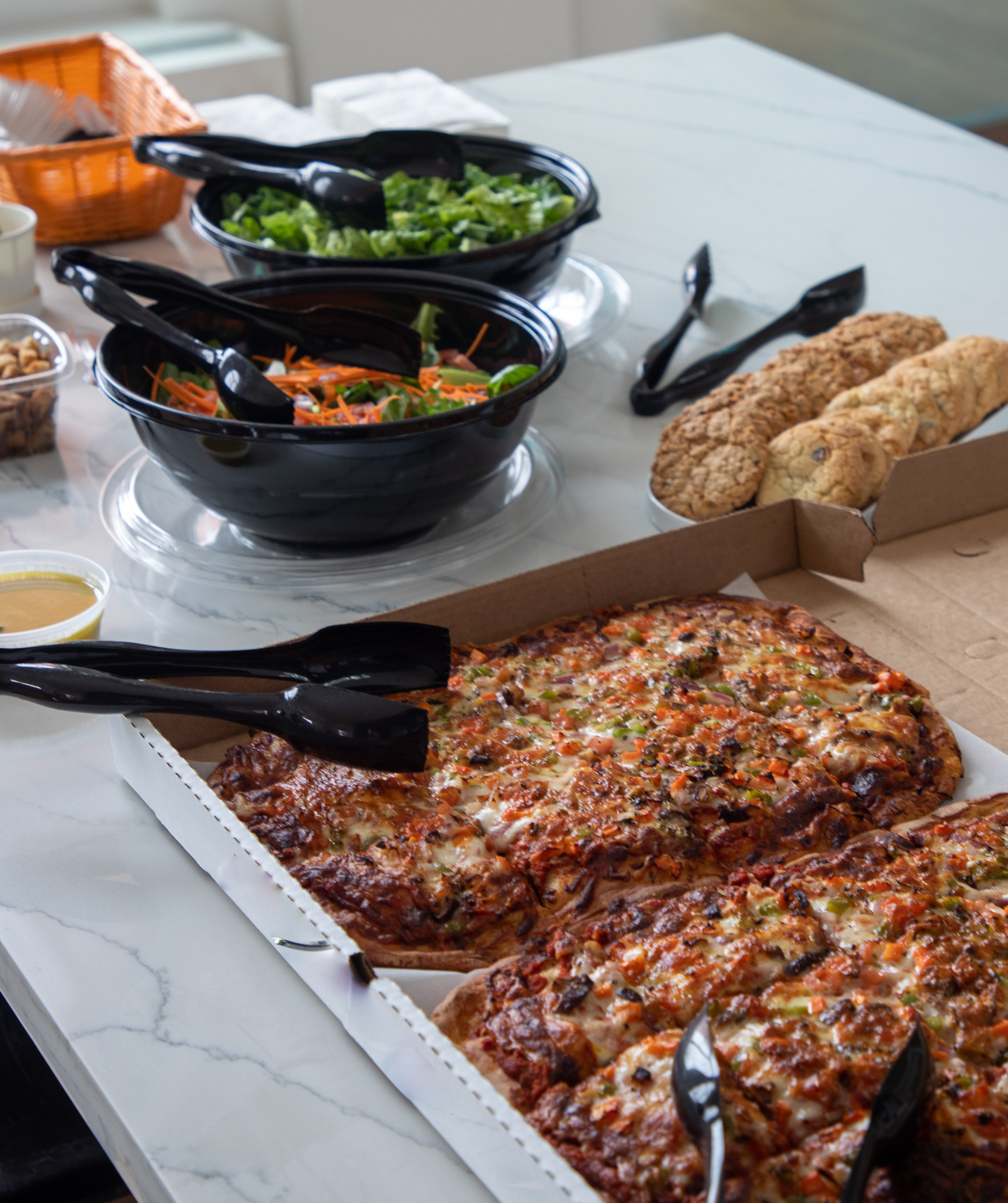 Pizza, salad, and cookies on a marble table