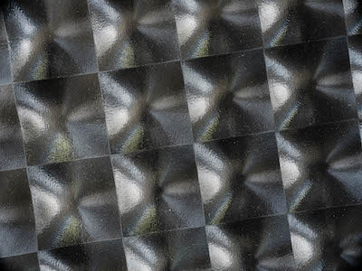Detail view of a highly glossy textured black fabric