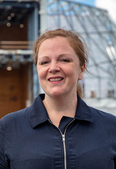 A headshot of a white woman wearing a black shirt