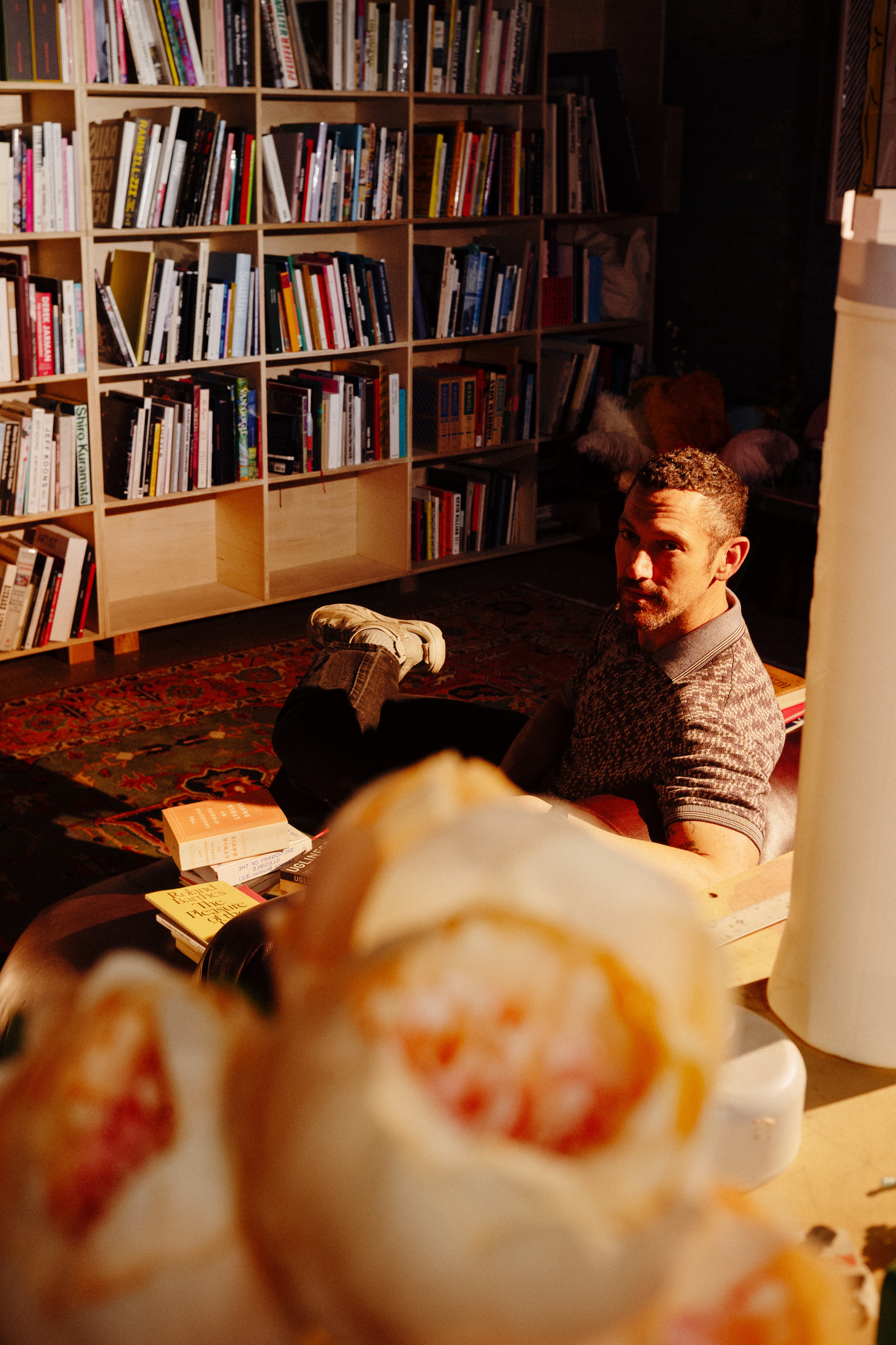 A person sitting down, looking over their shoulder at the camera