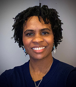 A headshot of a Black woman wearing a blue shirt