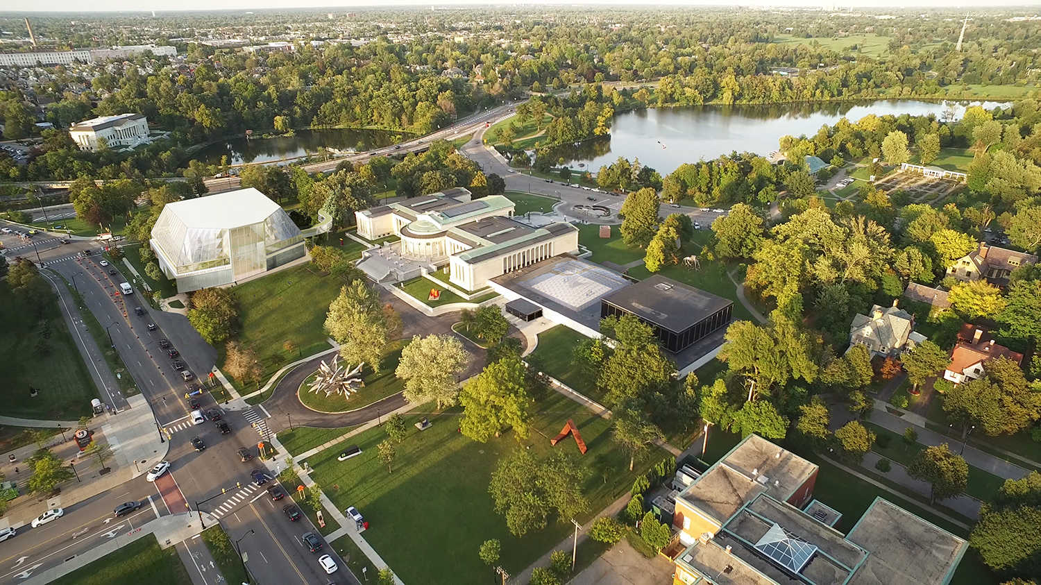 An aerial photograph of the museum's campus with a rendering of the new building in the top left