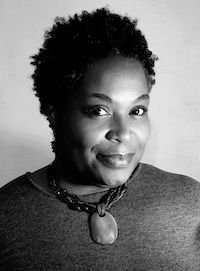 A black and white photo of a woman of dark skin tone and short tightly curled hair