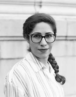 A black-and-white photograph of a woman with glasses and a long braid