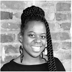 A black and white photograph of a Black woman with thick braids, some in a bun on top of her head, and two on the right side of her face