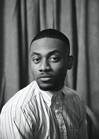 Black-and-white photograph of a man of dark skin tone from the shoulders up