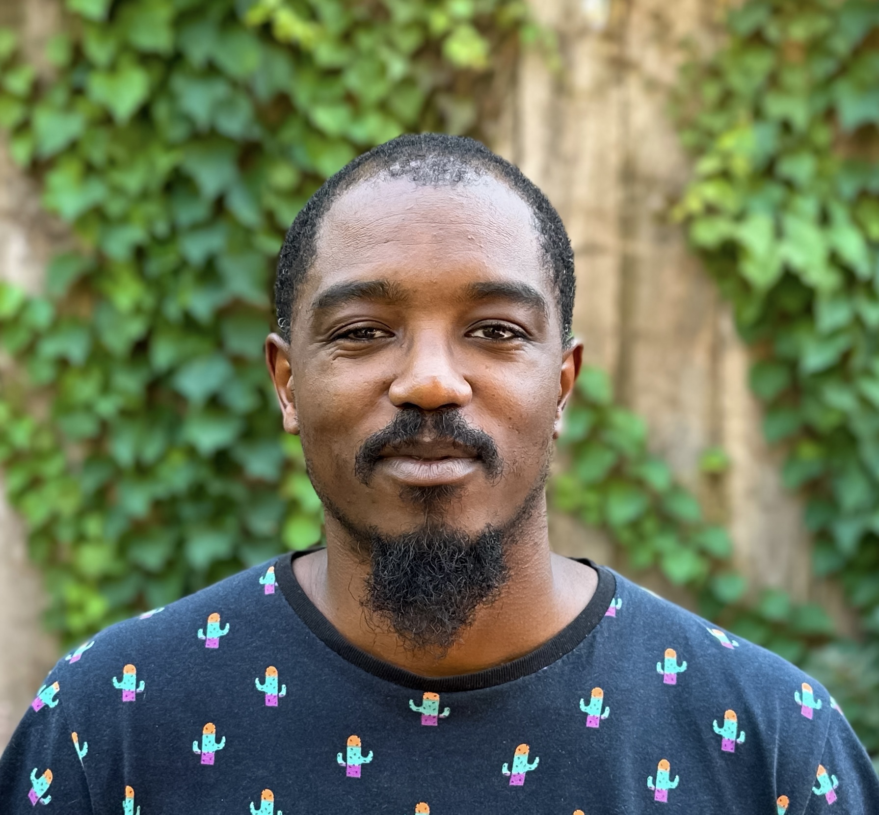 A photograph of a man with a beard that shows him from the shoulders up