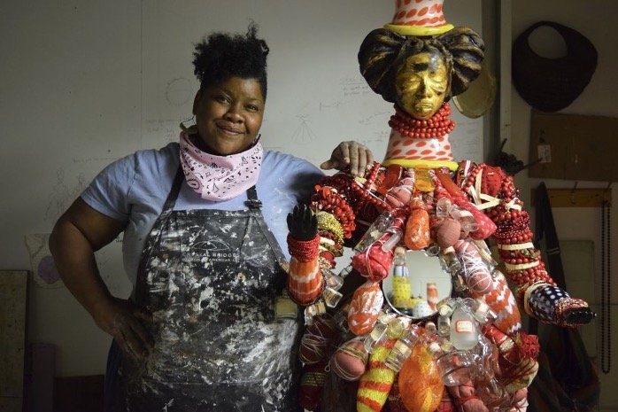 vanessa german posing with one of her sculptures