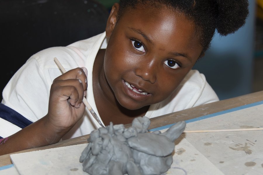 An African American girl making a ceramic animal