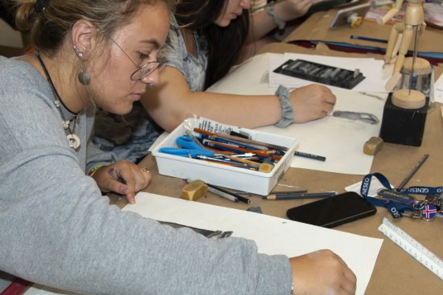 A table of teens painting together at a table