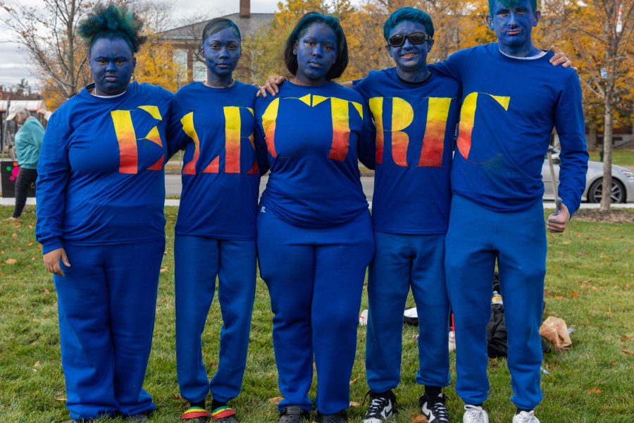 Five students wearing all blue with their shirts spelling out "Electric" in orange font