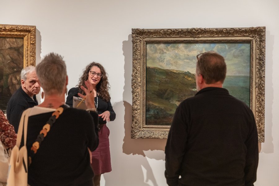 A woman leading a discussion about a painting