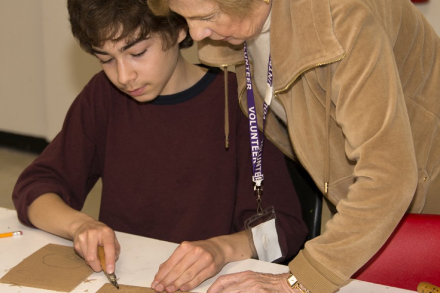 Volunteer with teen during an art class