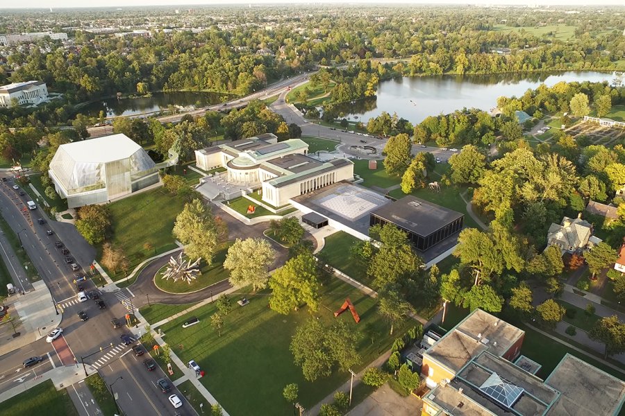An aerial view of the musuem's campus with a rendering of the new building in the upper left