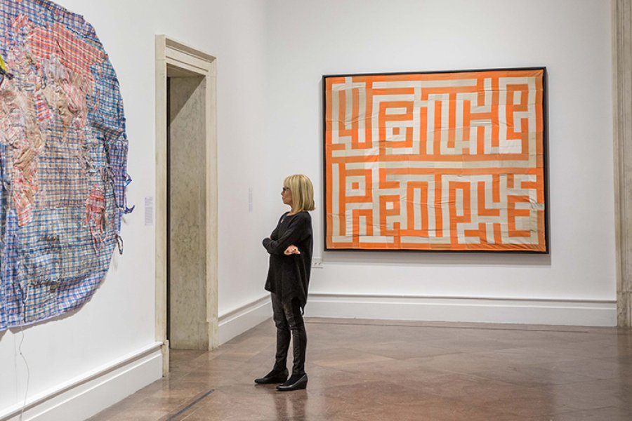 A woman looks at large works of art on the walls
