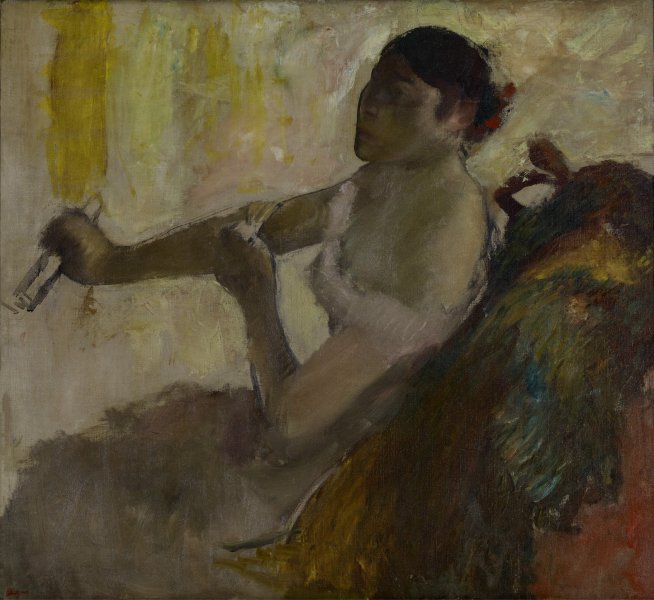 A woman wearing a low-cut pink evening dress and elbow-length gloves sits at the center of this horizontally oriented painting. What appears to be a multicolored furred or feathered garment rests on the back of her red chair. Her face, oriented left, is largely obscured by shadow. She clutches a folded fan in her right hand and adjusts the top of her left hand. The entire scene is loosely painted in a palette dominated by dark greens and yellows.
