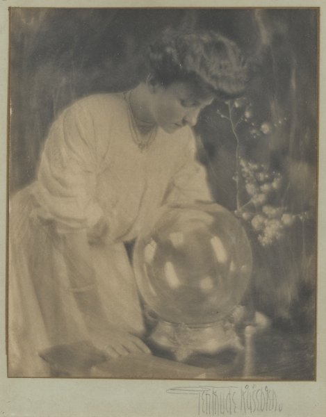 Charlotte S. Albright looking into a glass bowl or ball