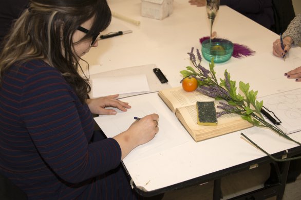 A woman makes a still life drawing in the education classrooms