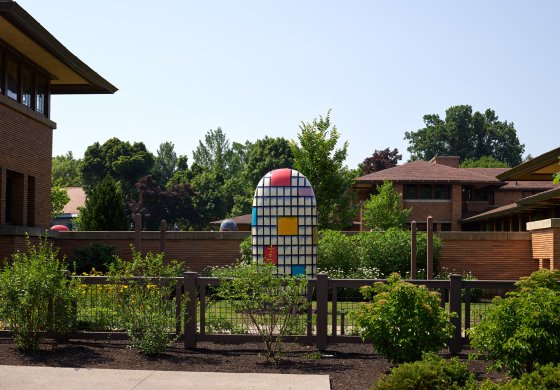 A large ceramic sculpture with color blocks and black horizontal and vertical lines