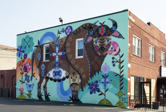 View of a mural of a brown buffalo on a blue-green wall