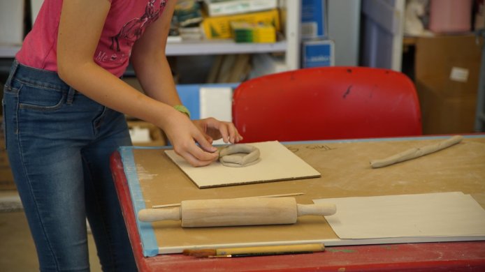 A young person forming clay