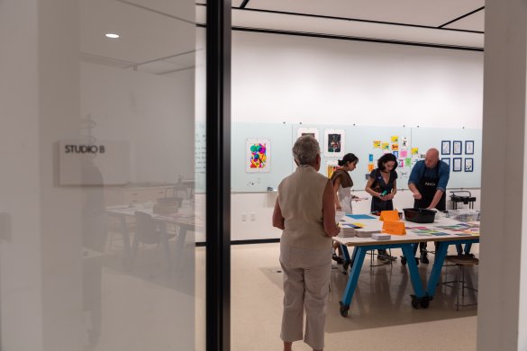 Photo taken behind a door looking into an art studio where four adults are working