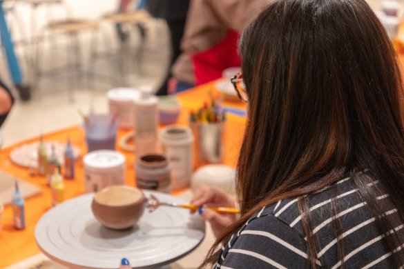 A woman painting a ceramic bowl