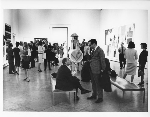 Black and white image of a crowd of people in an art gallery