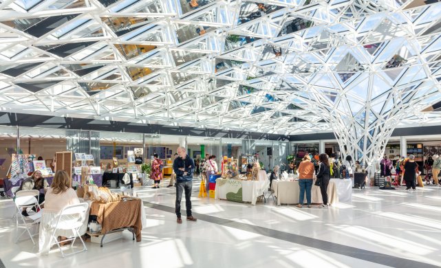 Vendors set up under a glass mosaic ceiling 