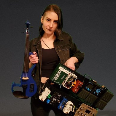 A person posiong with a guitar and soundboard