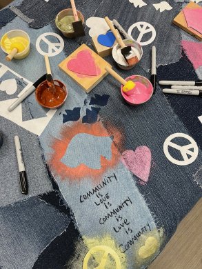 Various fabrics and stamps together with one fabric writing "Community is love is community is love is community" 