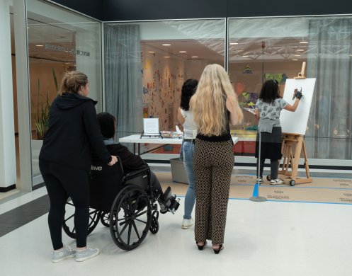 People watching an artist do a live painting demonstration