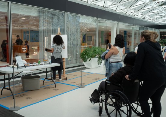People watching an artist do a live painting demonstration