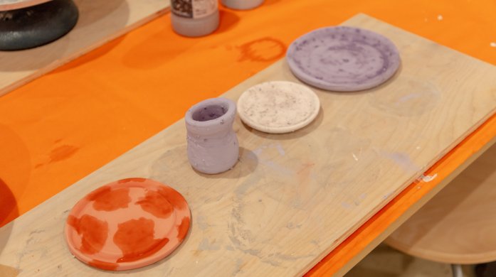 A table with different clay items including a bowl and a cup