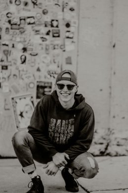 Black and white image of a person crouched down smiling