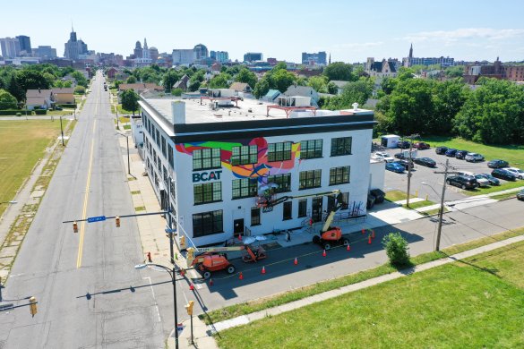 An in-progress mural on the side of a building with the word "BCAT" on it